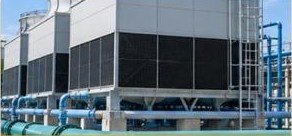 Industrial cooling towers and chilled water pipework on a plant rooftop